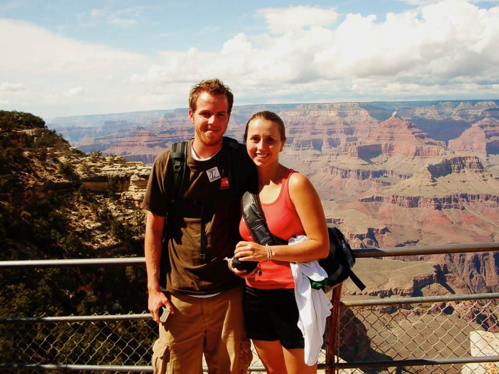 A young couple standing in front of a large canyon.