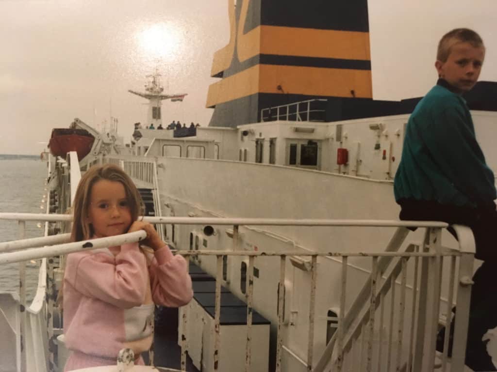 Two young children sitting on a large boat.