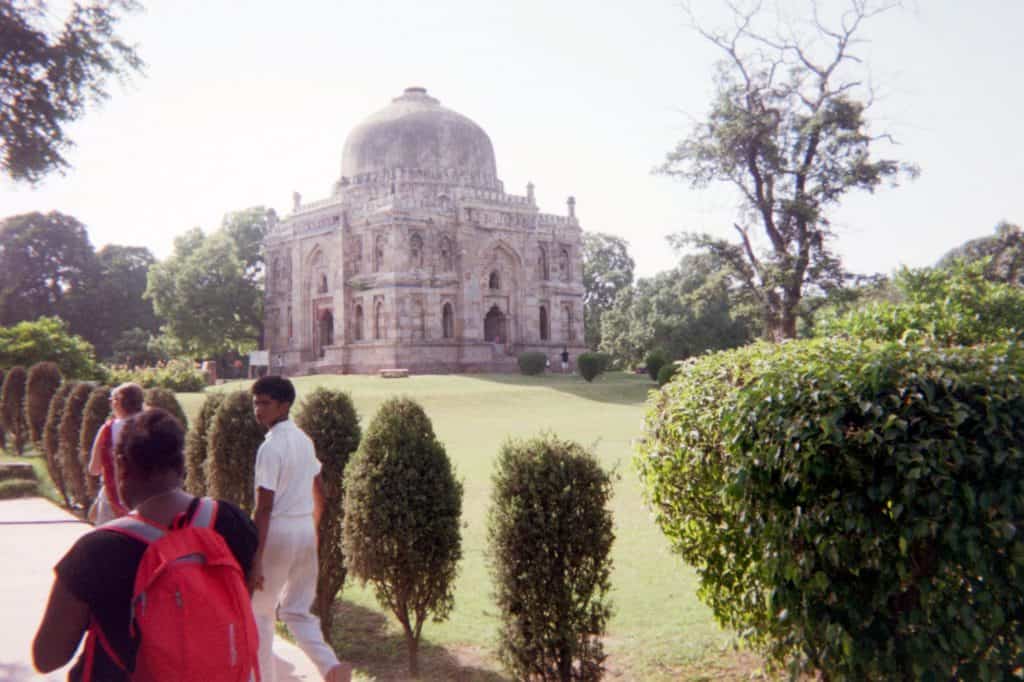 People walking by temple and garden in India